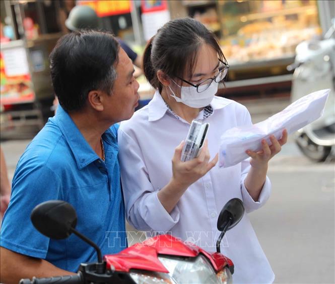 Phụ huynh động viên, dặn dò thí sinh trước khi vào phòng thi, tại điểm thi Trường THPT Thăng Long (quận Hai Bà Trưng). Ảnh: Thanh Tùng - TTXVN